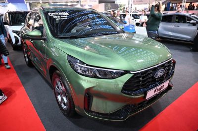 Car front view with prominent grille and sleek headlights in a shiny green finish
