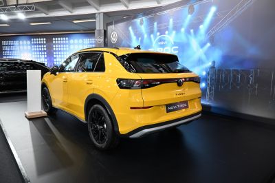 Rear view of yellow SUV with black alloy wheels.