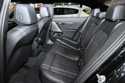 Rear seat area with black leather upholstery and detailed stitching