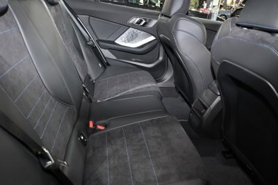Rear seat interior with leather and suede upholstery and blue stitching