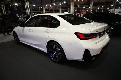 Rear side view of white sedan with distinct taillights and black alloy wheels