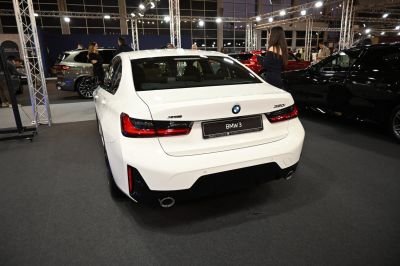 Rear view of a white sedan with distinctive tail lights and dual exhaust outlets