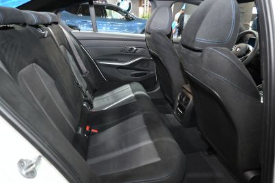 Rear seat interior with upholstery and blue stitching, rear air vents