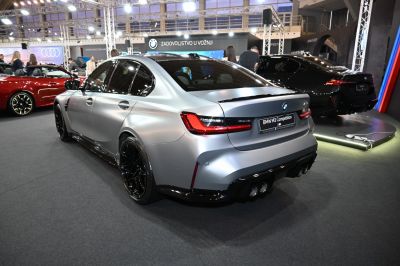 Matte silver high-performance sedan with quad exhaust and black sporty wheels