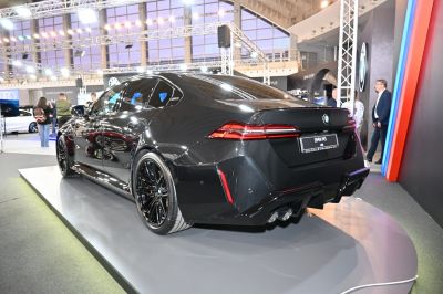 Sleek rear and side view of black sedan with multi-spoke wheels