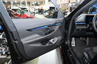 Modern interior door panel with carbon fiber accents and ambient lighting.