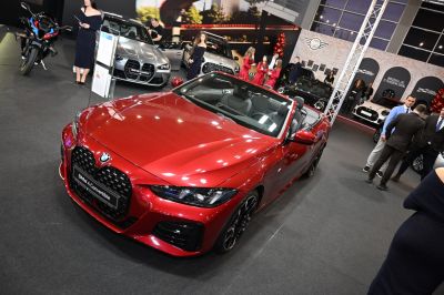 Front view of a red convertible with large grille and LED headlights