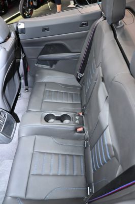 Rear black leather seats with blue stitching and cup holders