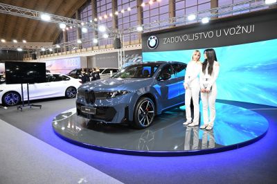 Blue electric SUV with sharp headlights and sporty wheels on rotating platform
