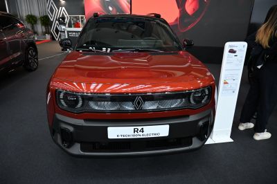Front view with distinct headlights and sleek fascia of a fully electric vehicle.