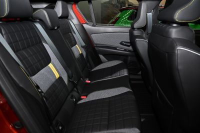 Rear seats with quilted black fabric and yellow stitching in modern interior.
