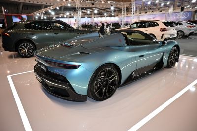 Rear quarter view of a sleek open-top sports coupe with aerodynamic rear design.