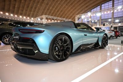 Sleek blue convertible with aerodynamic design and black multi-spoke rims