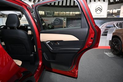 Beige and black rear door interior panel with armrest and controls