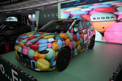 Car with unique colorful pebble-pattern wrap and sleek design.