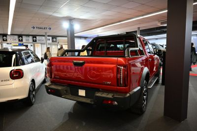 Double cab pickup truck with embossed tailgate and roll bar