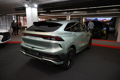 Modern SUV rear with continuous LED taillights and quad exhaust tips.