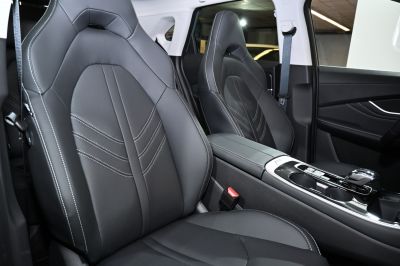 Premium black leather seats with white stitching and center console.