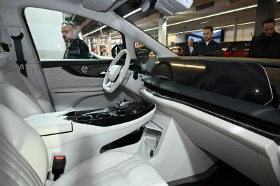 Modern digital dashboard and white leather steering wheel in car interior