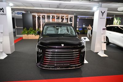 Front view with wide chrome grille and vertical LED headlights