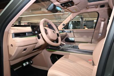 Luxurious beige leather interior with dual digital displays and ambient lighting