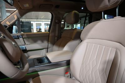 Beige leather front seats and central armrest with detailed stitching