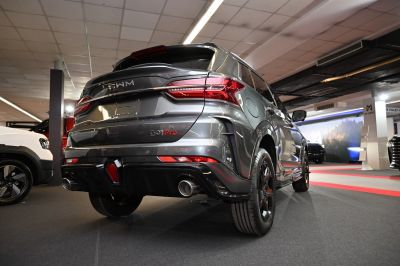 SUV rear view showcasing taillights and dual exhaust pipes.