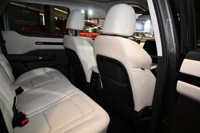 Spacious rear seats with light leather upholstery and storage nets on seat backs.