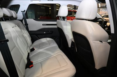 Spacious rear passenger seating with light upholstery, seat belts, and headrests