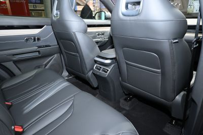 Rear black leather seats and central air vents in a car
