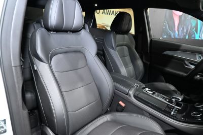 Luxury black leather front seats with center console and control panel.