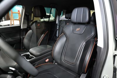 Sporty black leather seats with orange stitching and integrated headrests