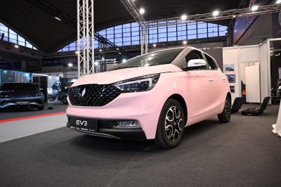 Compact electric vehicle front with LED headlights and black grille
