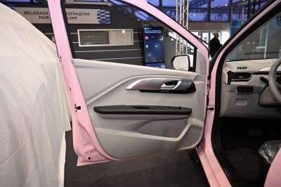 Interior door panel with handle, window controls, and speaker