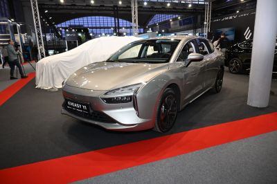 Front three-quarter view of modern electric sedan with sharp LED headlights.