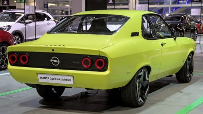 Bright lit coupe rear with circular red taillights and modern wheels