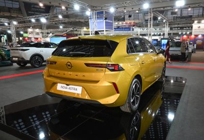 Rear view of yellow hatchback with hybrid badge and modern taillights