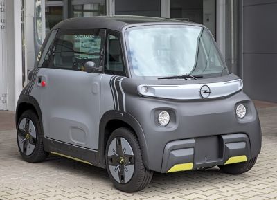 Compact electric urban vehicle with distinctive front lights and wheel design