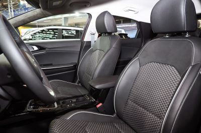 Modern black front seats with white stitching and patterned fabric inserts