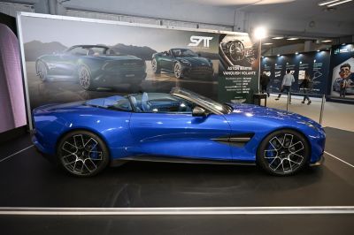 Side view of a blue convertible sports coupe with aerodynamic design.