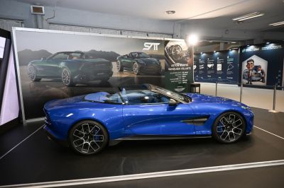 Blue convertible side view with sporty alloy wheels and open roof