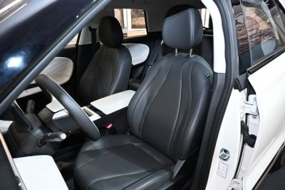 Modern black leather front seats with white quilted door accents