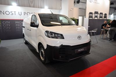 Front-left view of a white commercial van with large grille and updated headlights.