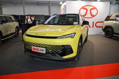 Front view of bright yellow SUV with LED headlights and hexagonal grille.
