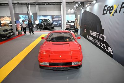 Front view of a red sports car with pop-up headlights and sleek aerodynamic design