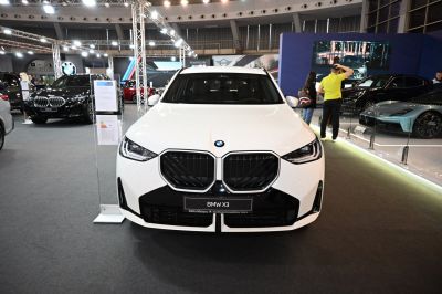 Front view with large kidney grille and sleek headlights in white.