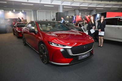 Sleek red electric sedan with illuminated grille and sharp headlights