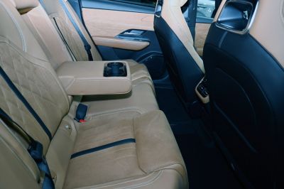 Rear tan leather seats with quilted pattern and fold-down armrest with cup holders