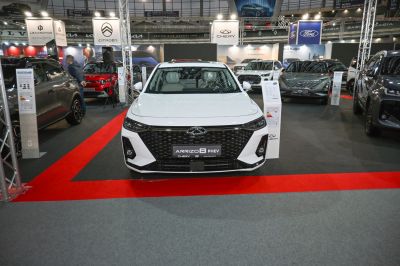 White vehicle front with large black grille and LED headlights