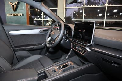 Modern car interior with touchscreen display and premium steering wheel.